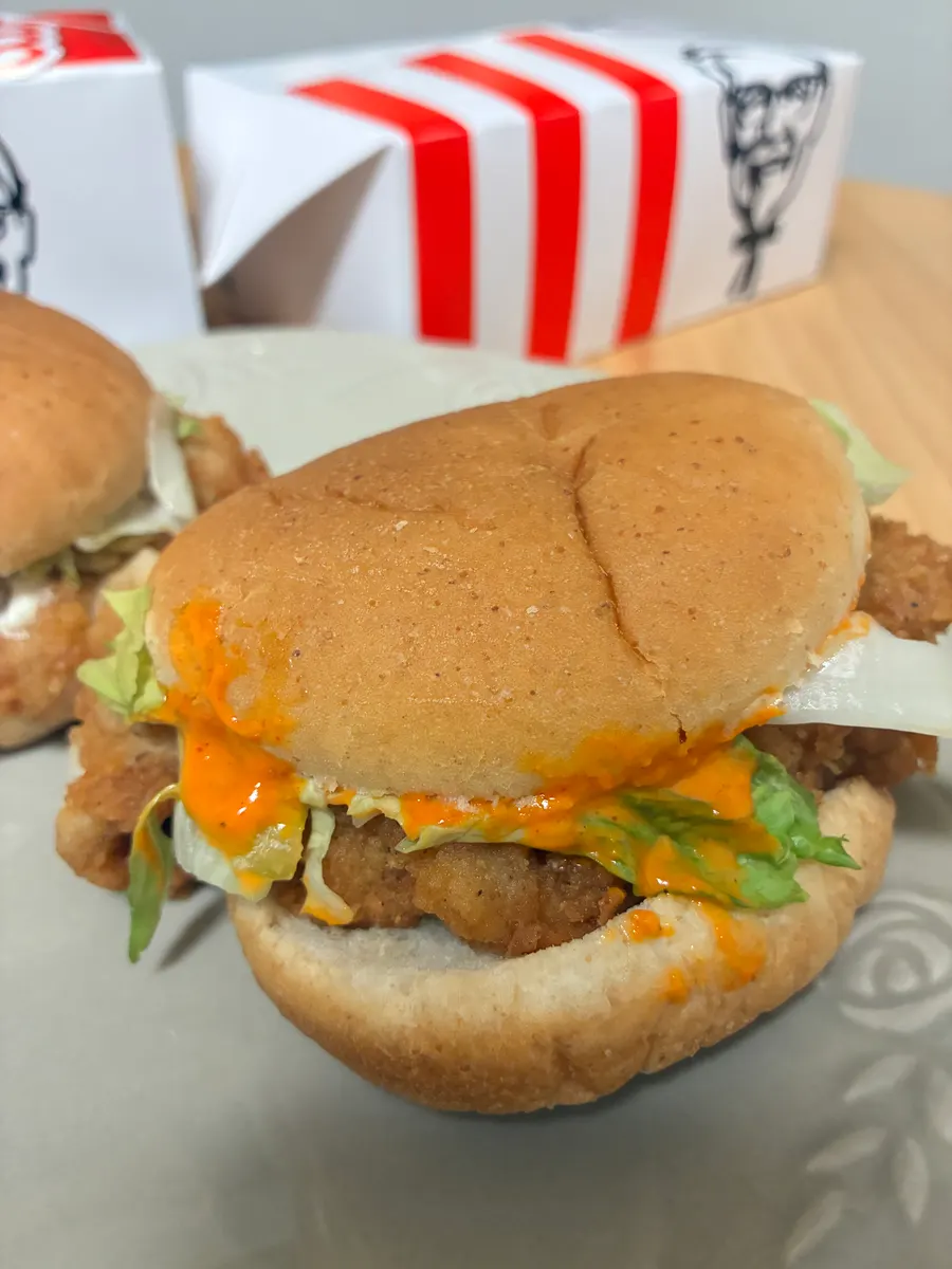 オレンジ色のソースとレタスを挟んだレッドホットソースのバーガー