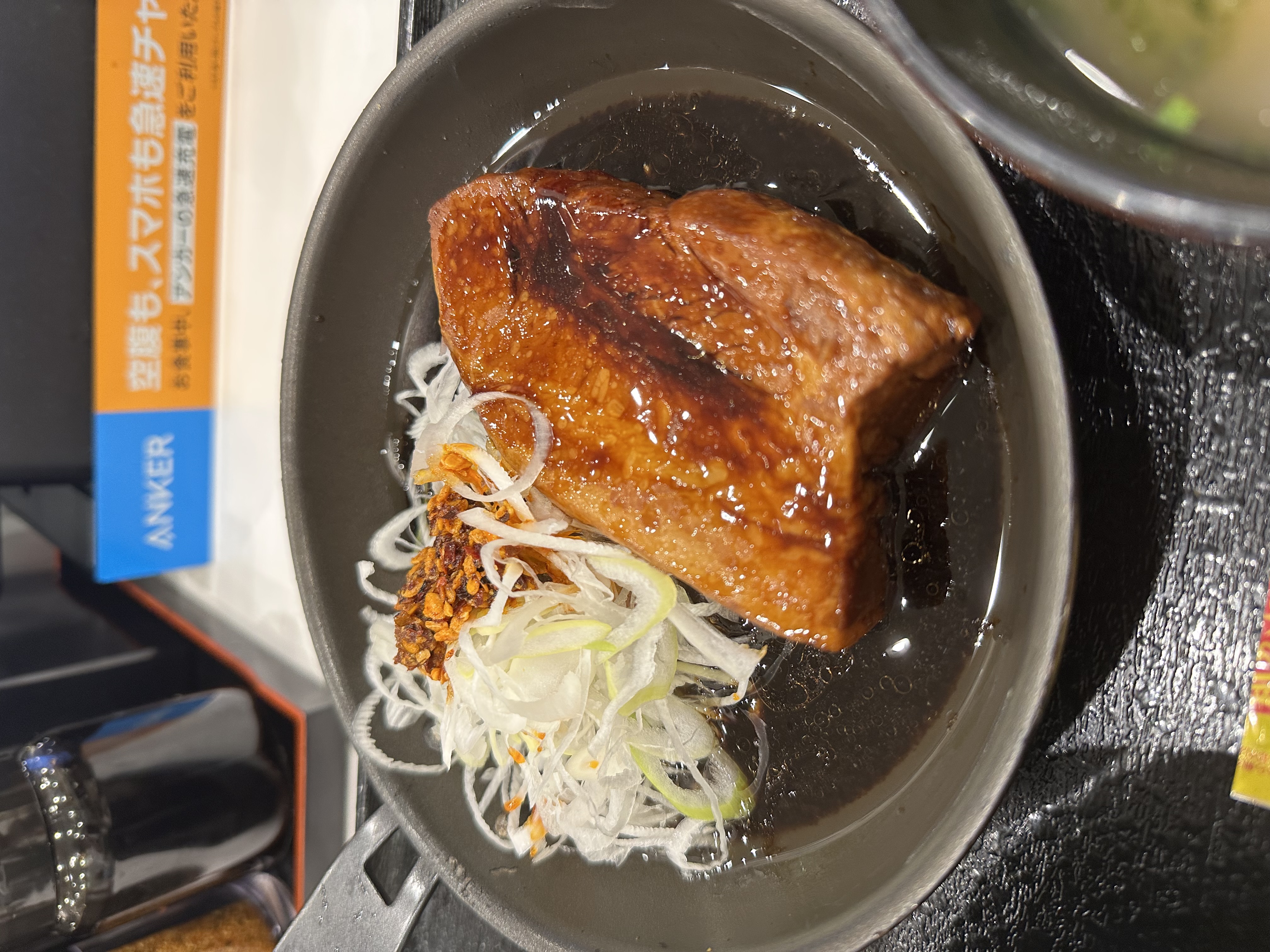 厚切りの豚角煮と、食べるラー油をのせた白髪ねぎのアップ